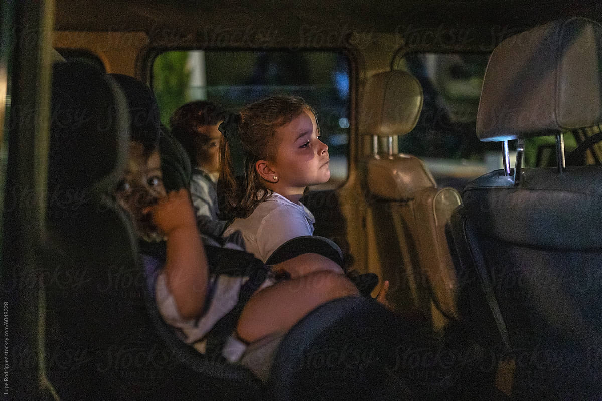 little children riding in the car at night