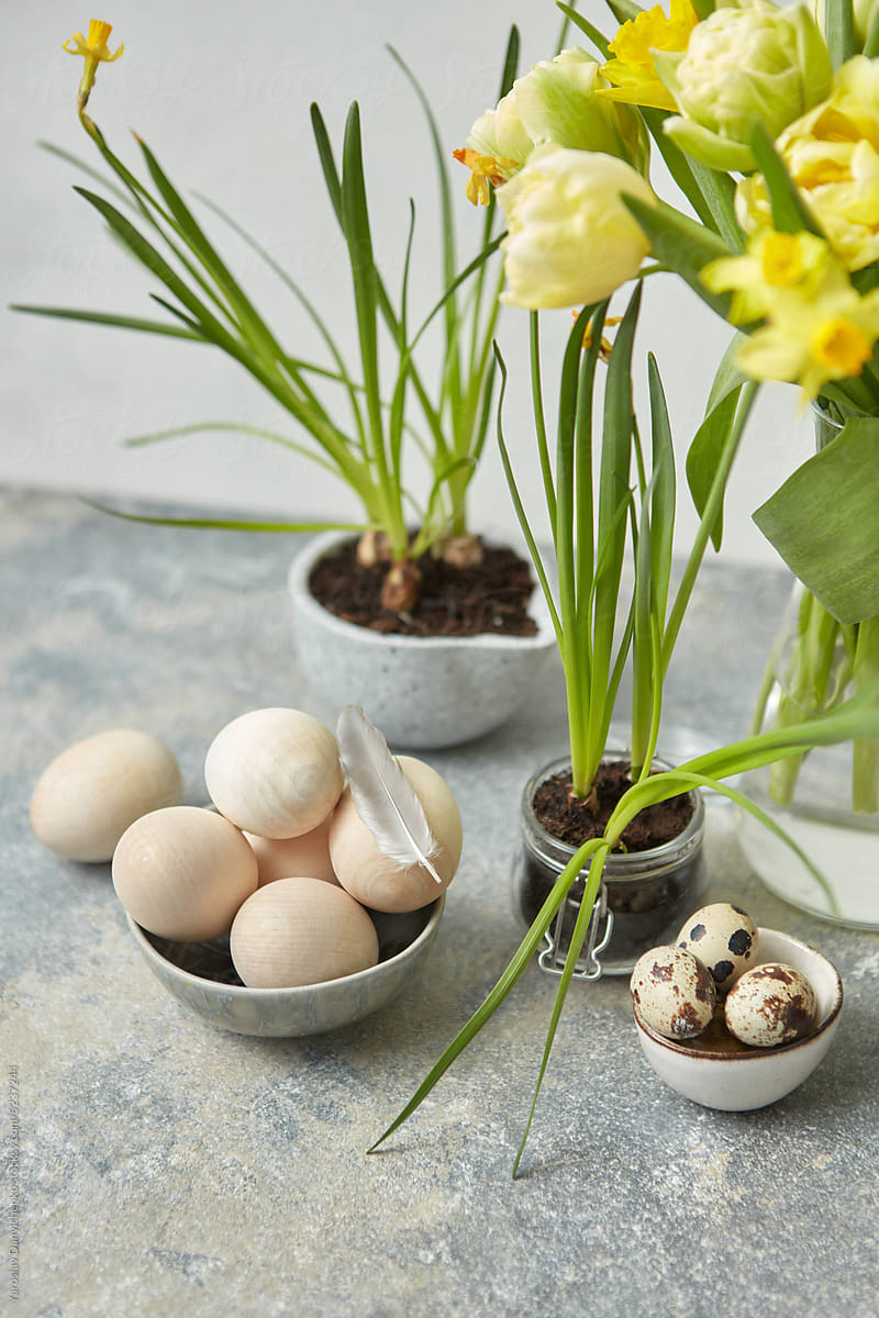 Wooden Easter and quail eggs with spring flowers.