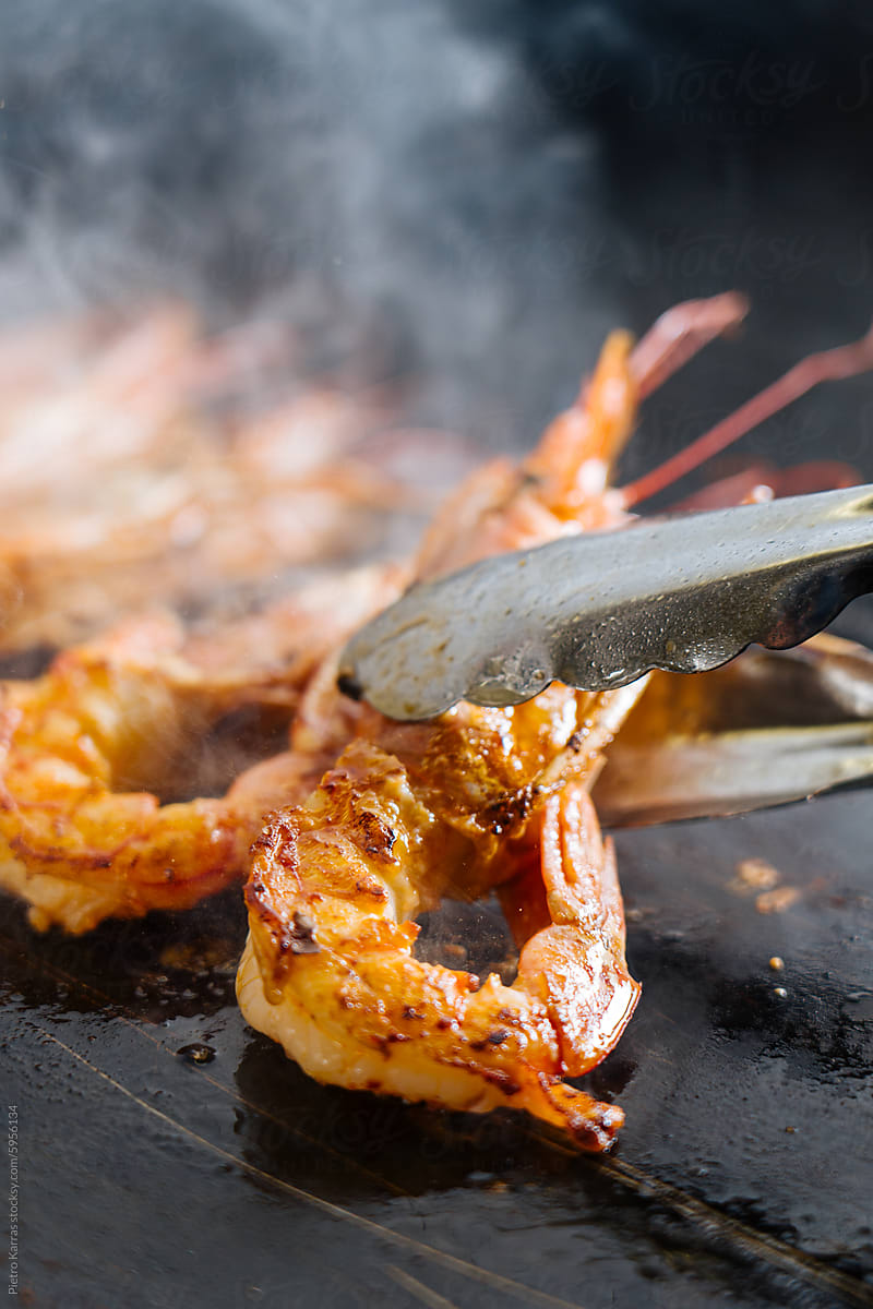 Cook flipping Shrimp on a Grill