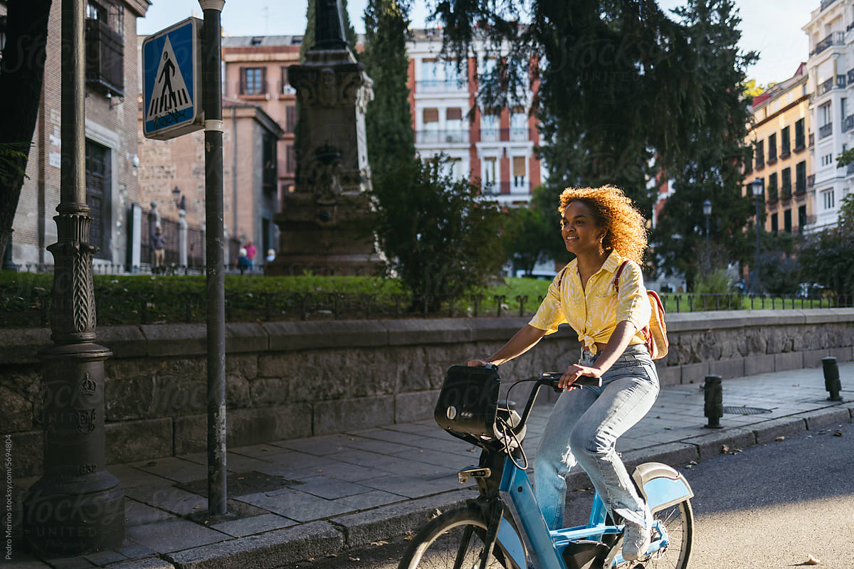 A stylish woman commuting in the city with an electric bike