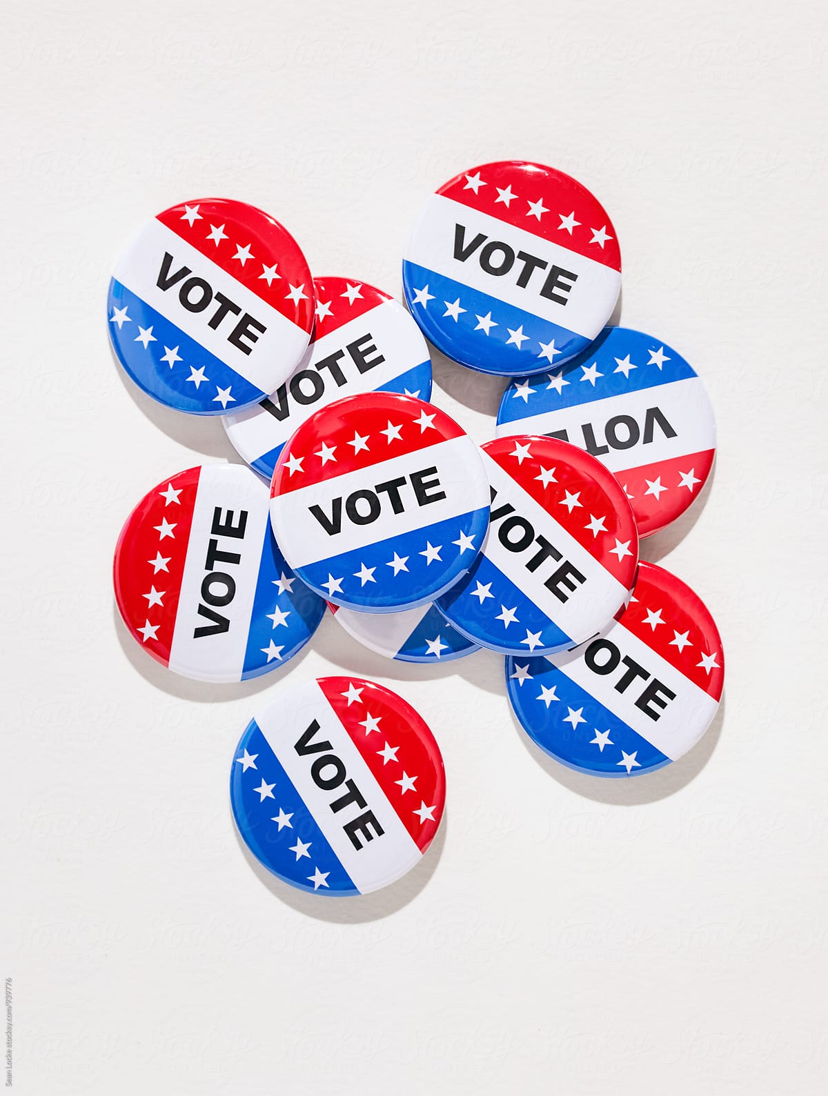 Vote: Pile Of Voting Pins On White Textured Background