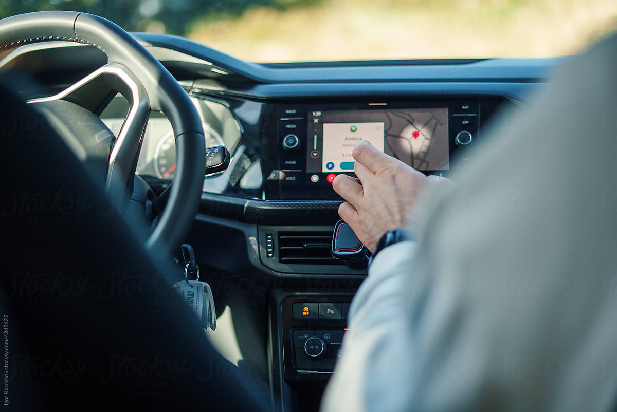 Man touching GPS navigator screen on car dashboard