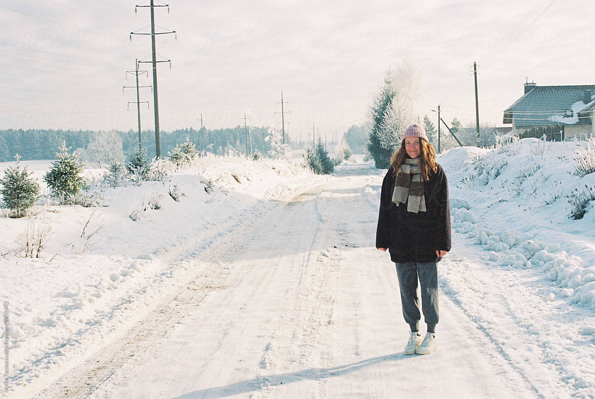 Young smiling woman on a snowy road in the village