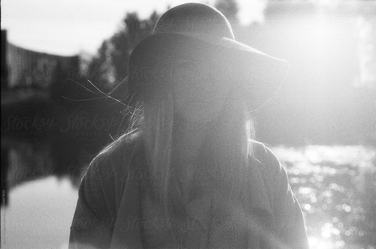Dreamy woman in a hat in a park in a sunny day