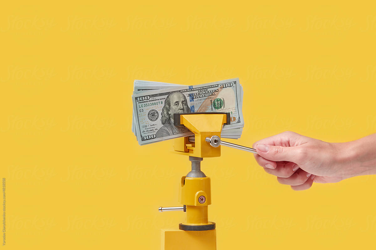 Dollars pressed by clamp operating by woman.
