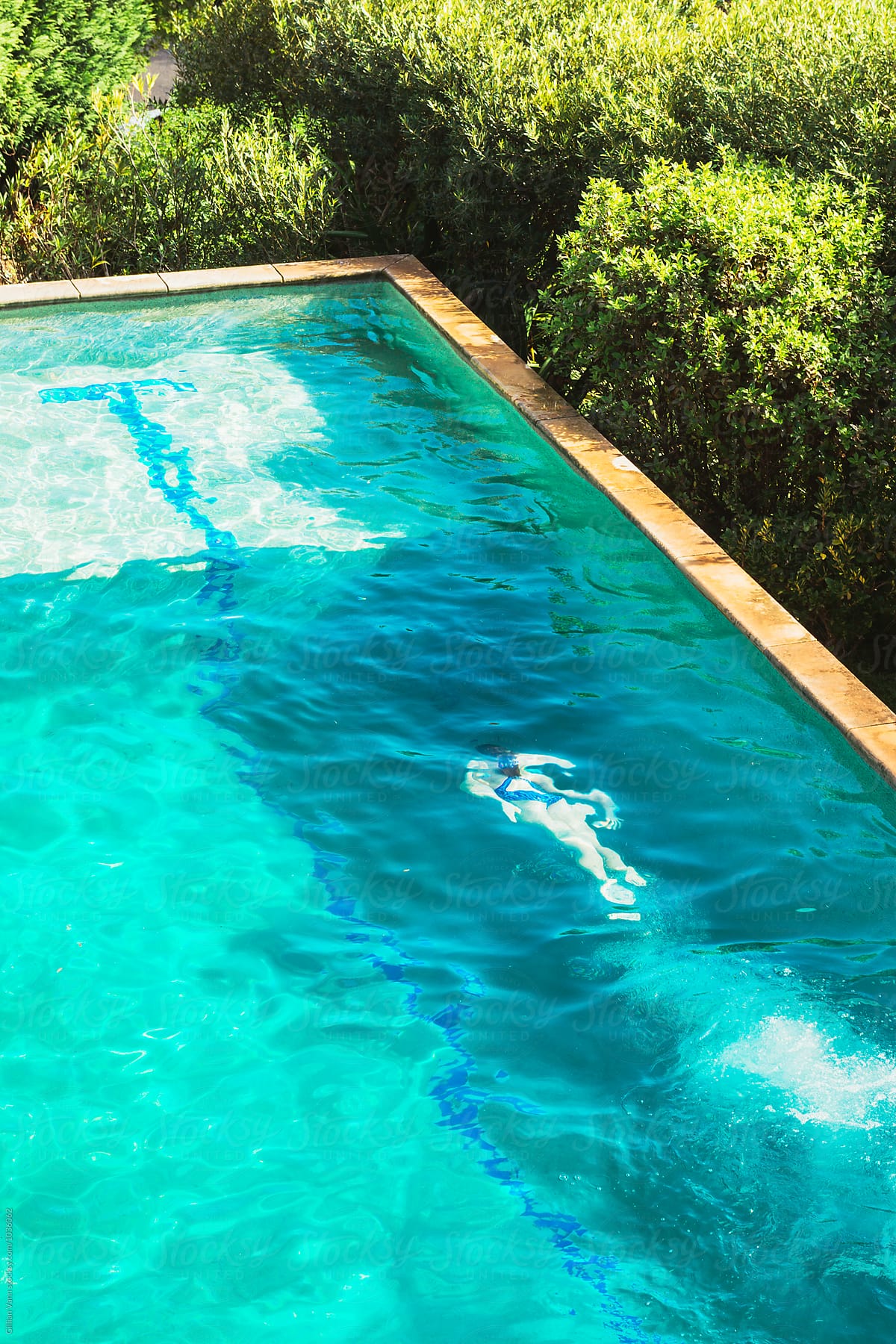 Overhead View Of Teenage Girl Swimming In A Backyard Pool By Stocksy