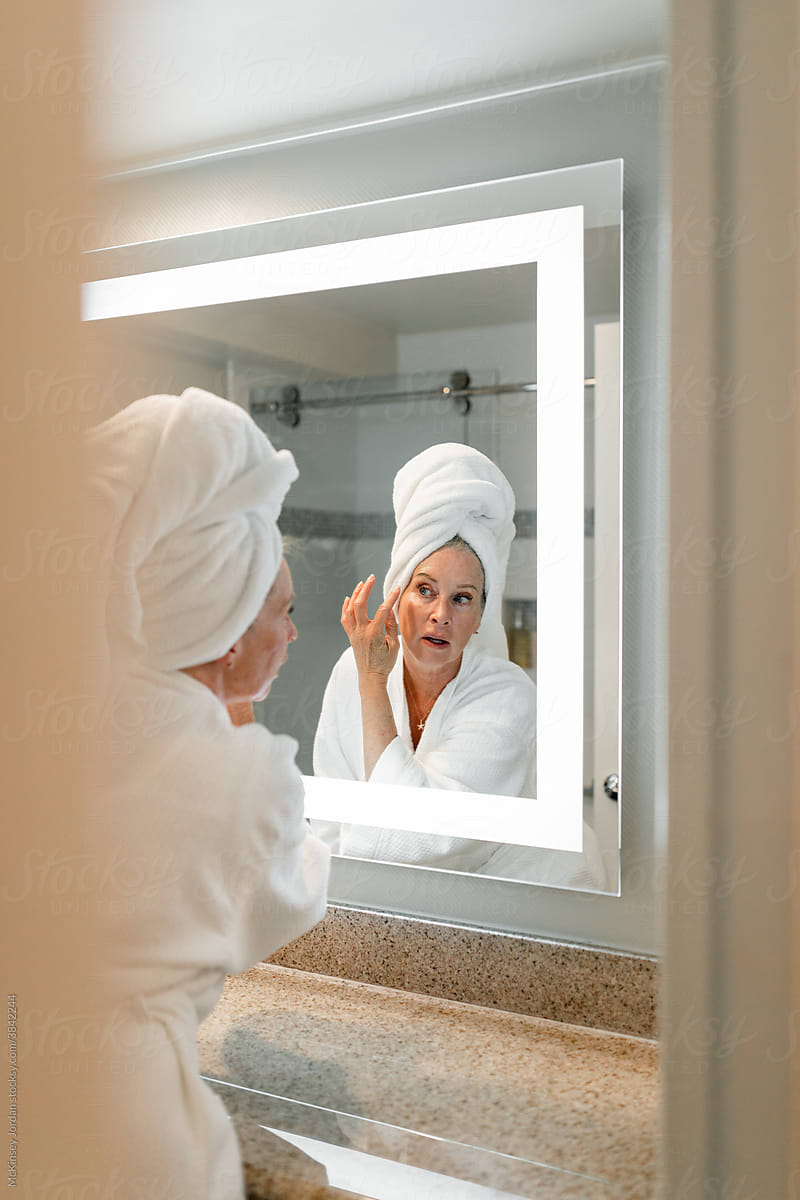 Woman Puts on Powder in Bathroom Mirror
