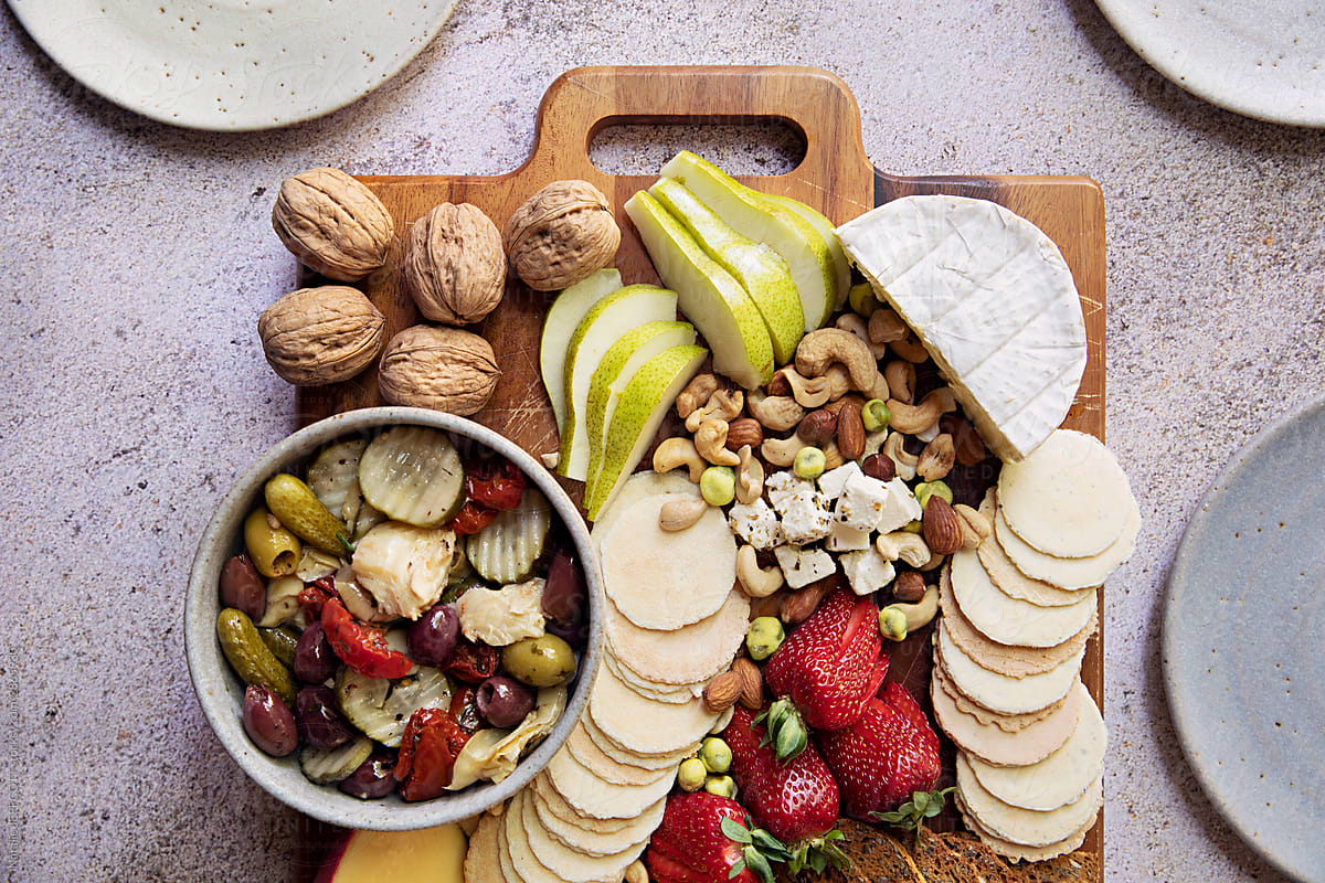 Overhead photo of a meat and cheese platter with fruit and nuts