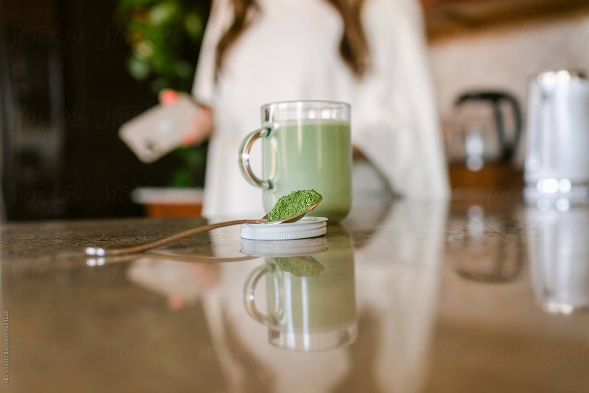 Green matcha tea latte on granite kitchen counter