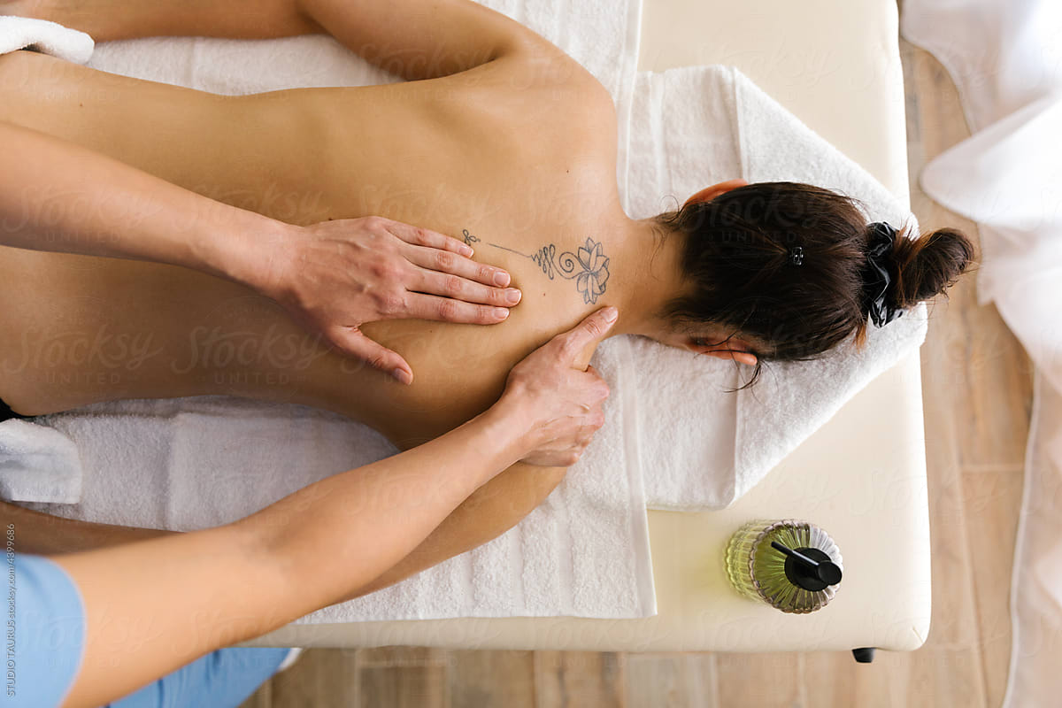 Unknown masseuse massaging caucasian woman