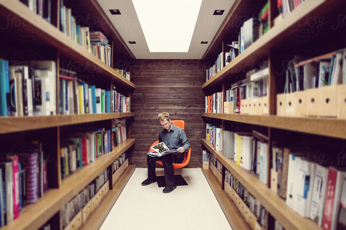 Solitary male in office library reading