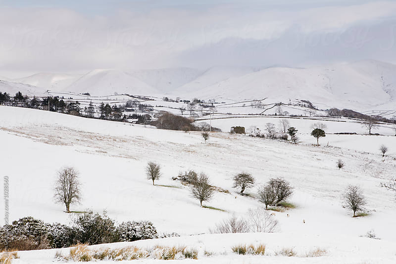 Snow covered mountains and farmland. Cumbria, UK.