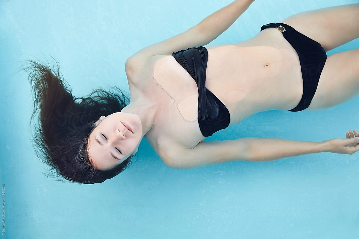 Woman floating in water in swimming pool