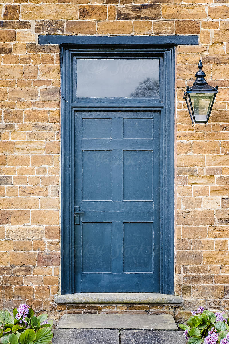 Blue door in a sandstone wall with a light