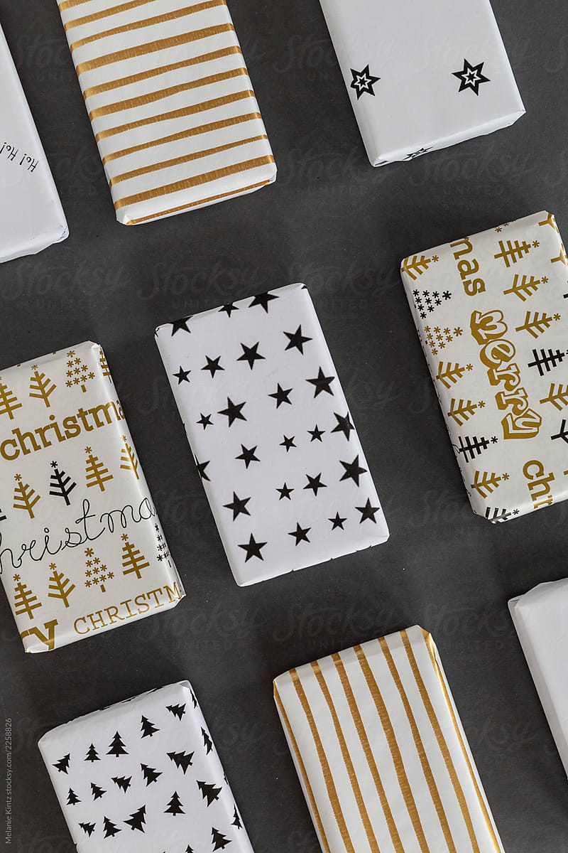Different boxs wrapped in white, gold and black paper