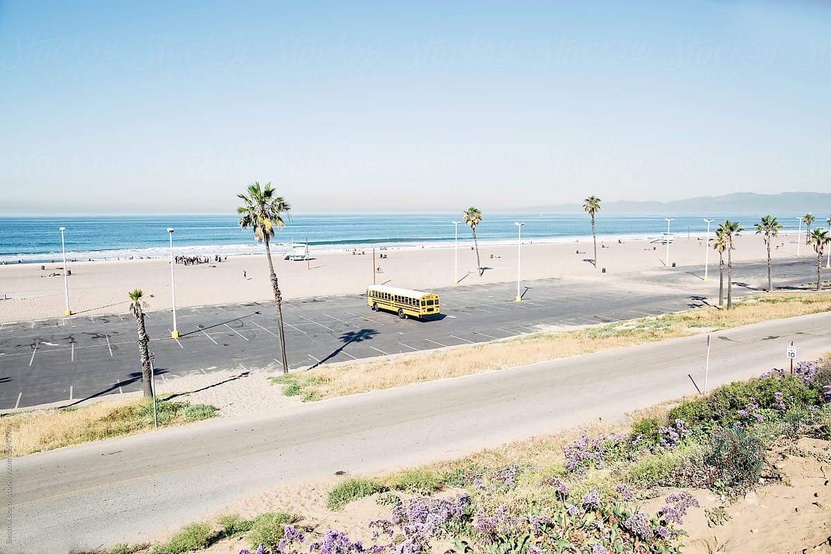 School bus and lots of students on a Californian beach