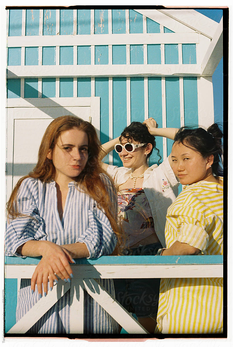 Three young female friends traveling together by the ocean. Friendship