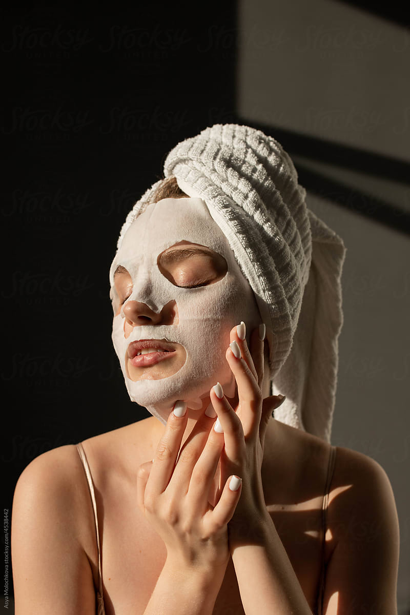 Young woman enjoying her applying face mask after shower