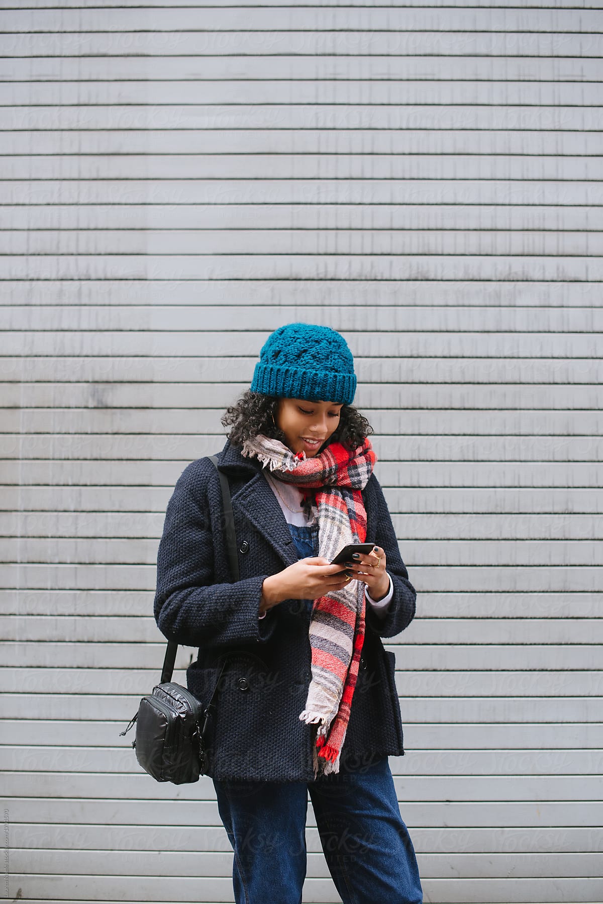 Young woman on phone in city on cold day