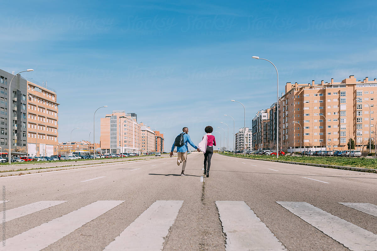 Black couple running along an empty road