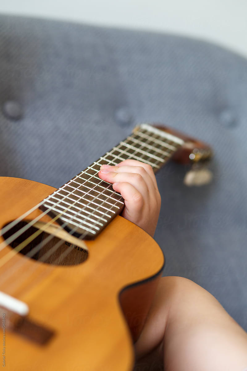 Boy holiding a small guitar\'s neck