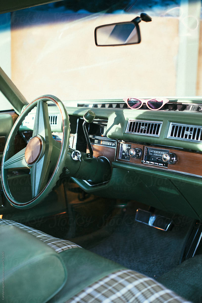 Interior of a pristine classic car with green plaid upholstery