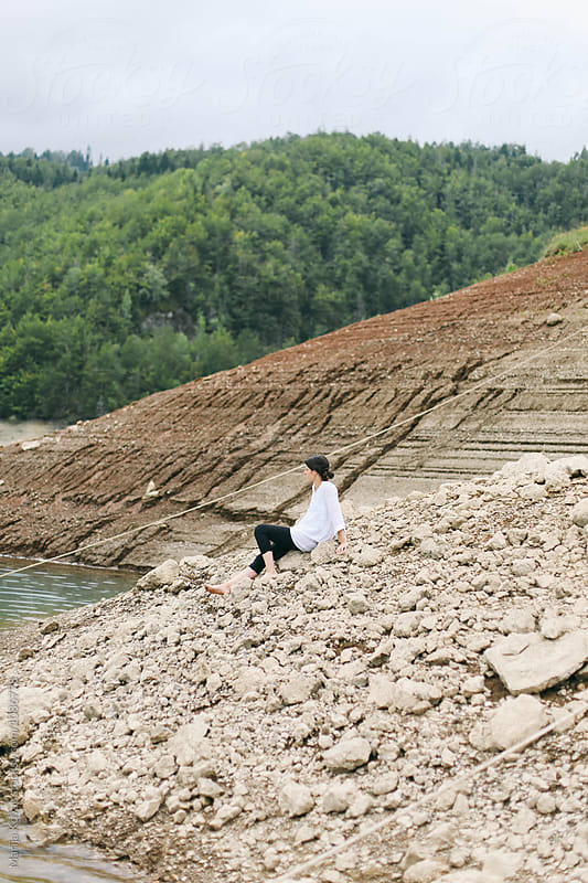 Brunette woman sitting on the rock