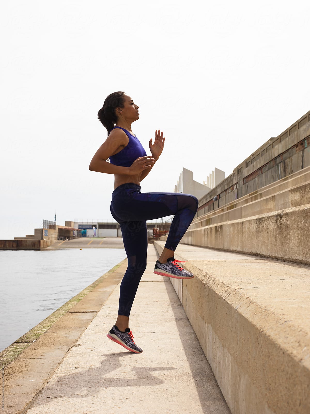 Sportive black woman training endurance on seafront