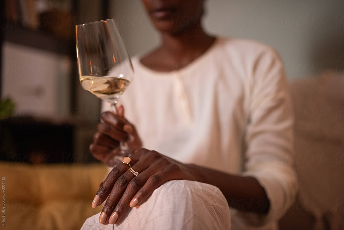 Crop black woman holding glass of white wine