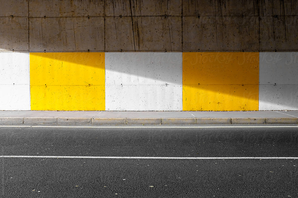 Tunnel wall with yellow and white paint.