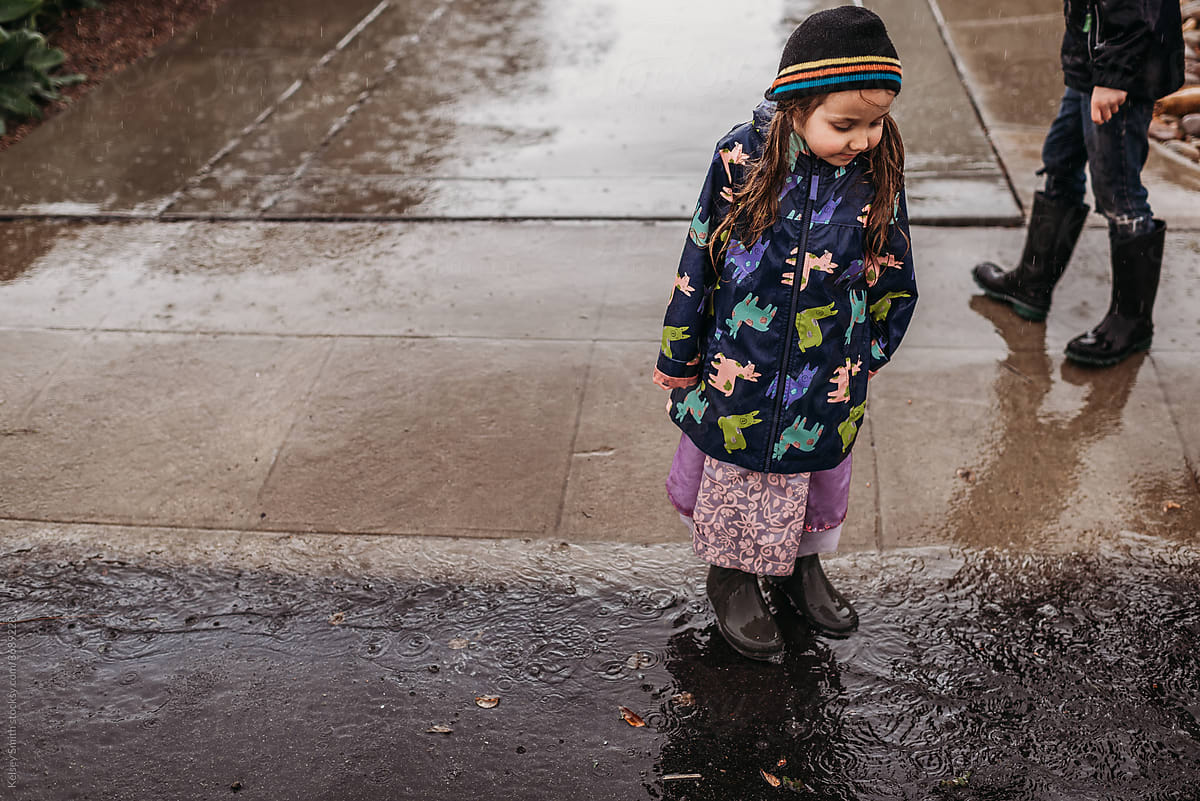 Little girl standing in puddle