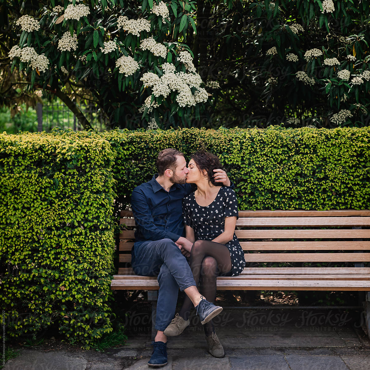 Couple kissing on park bench