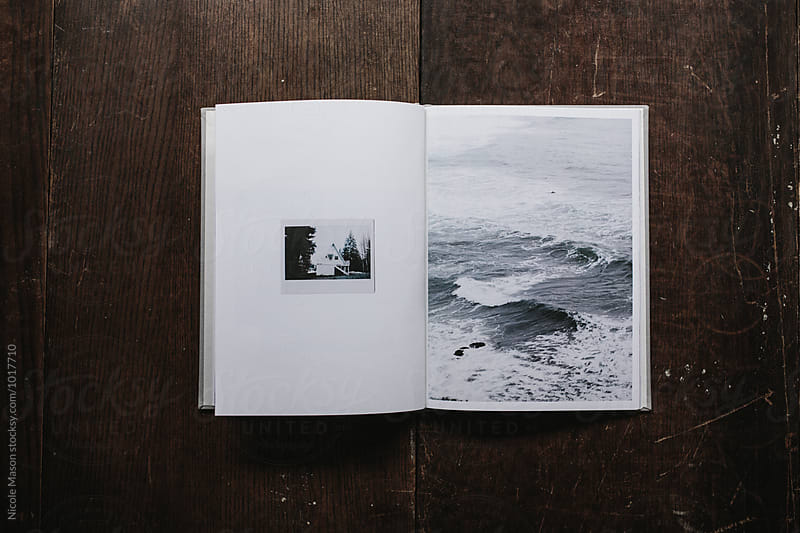 book of coast inspired photographs open on wood table