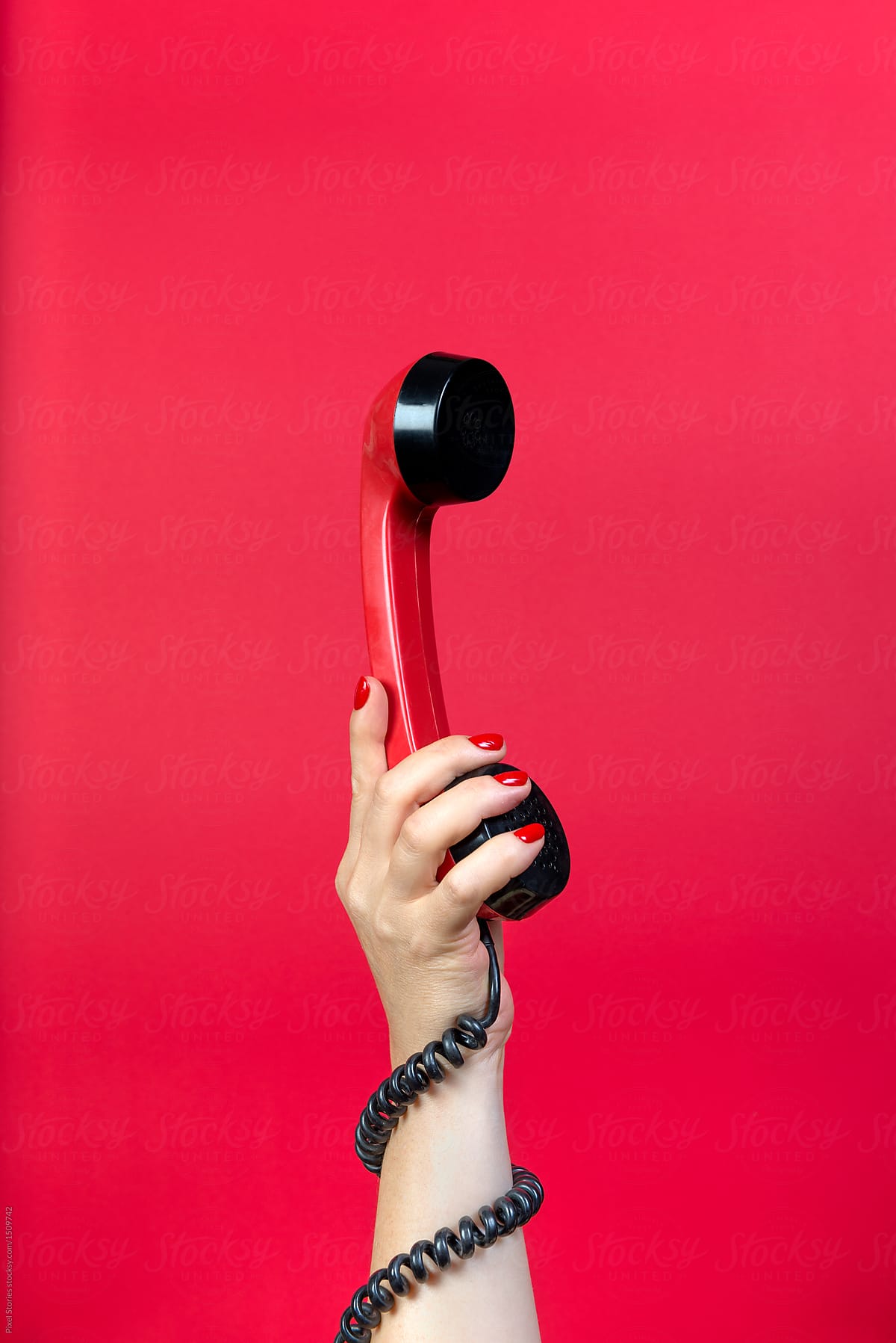 Hand holding red rotary phone