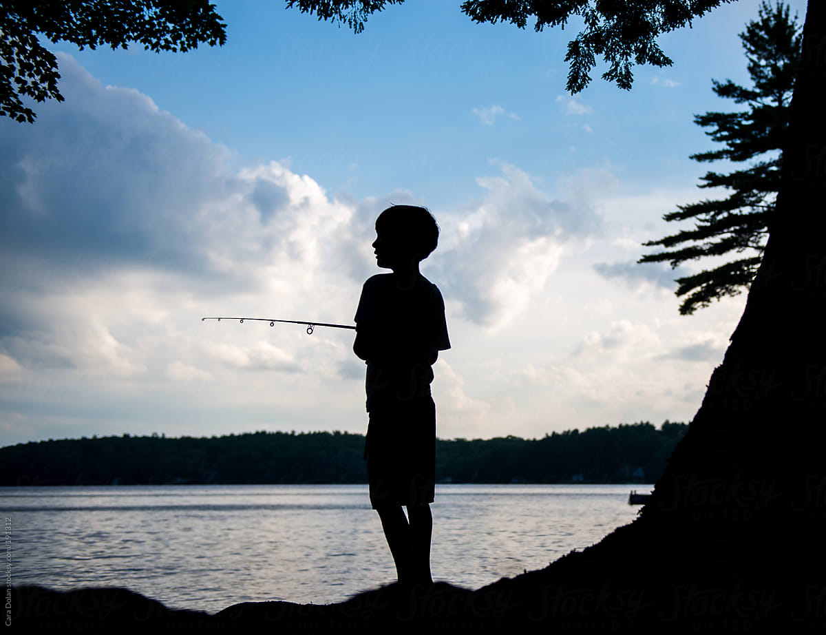 Silhouette Of A Boy Fishing On A Lake At Sunset by Stocksy Contributor  Cara Dolan - Stocksy