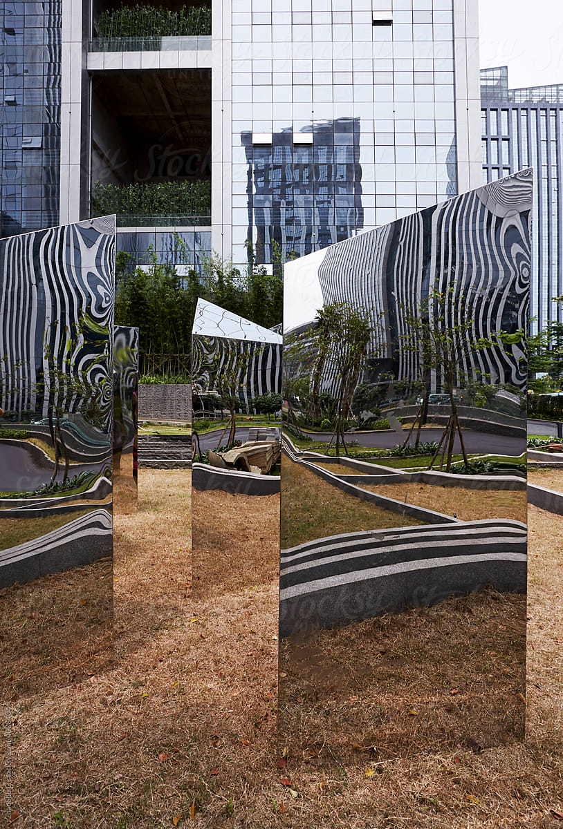 Mirror stainless steel art installation in the outdoor garden of a modern office building