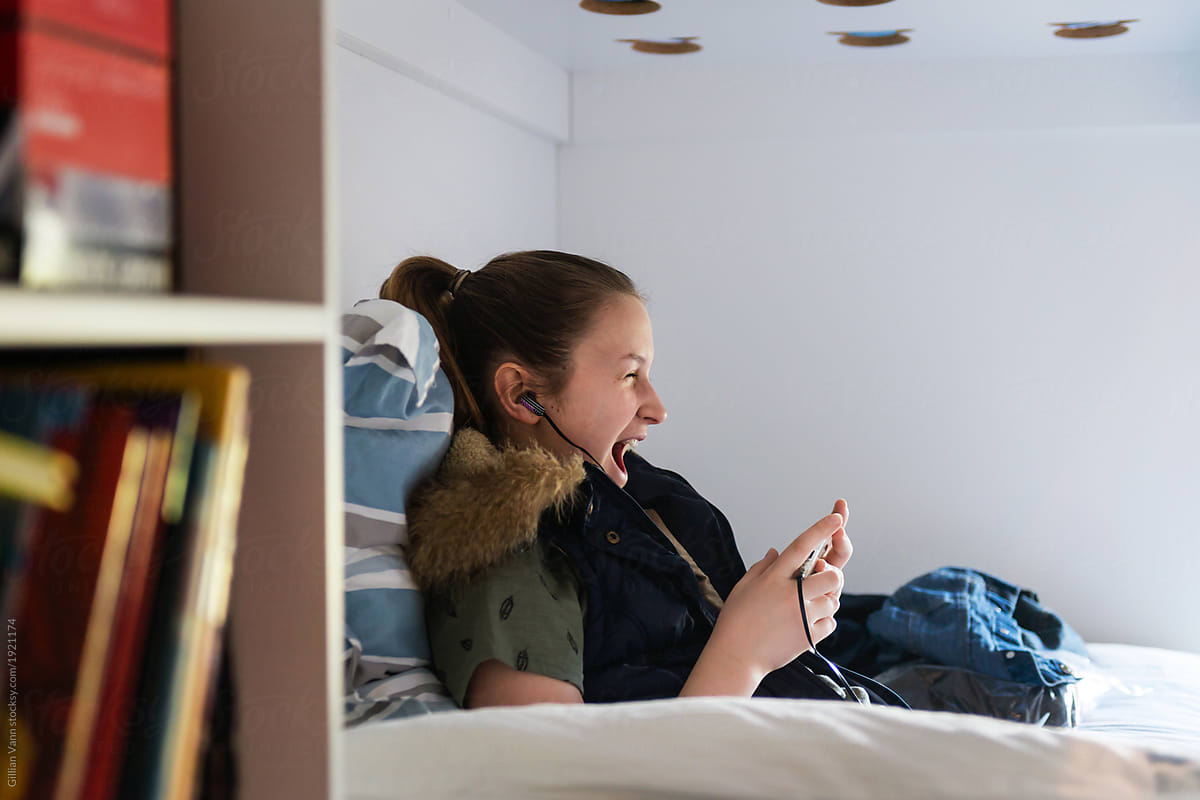 young teen girl listing to music in her room alone