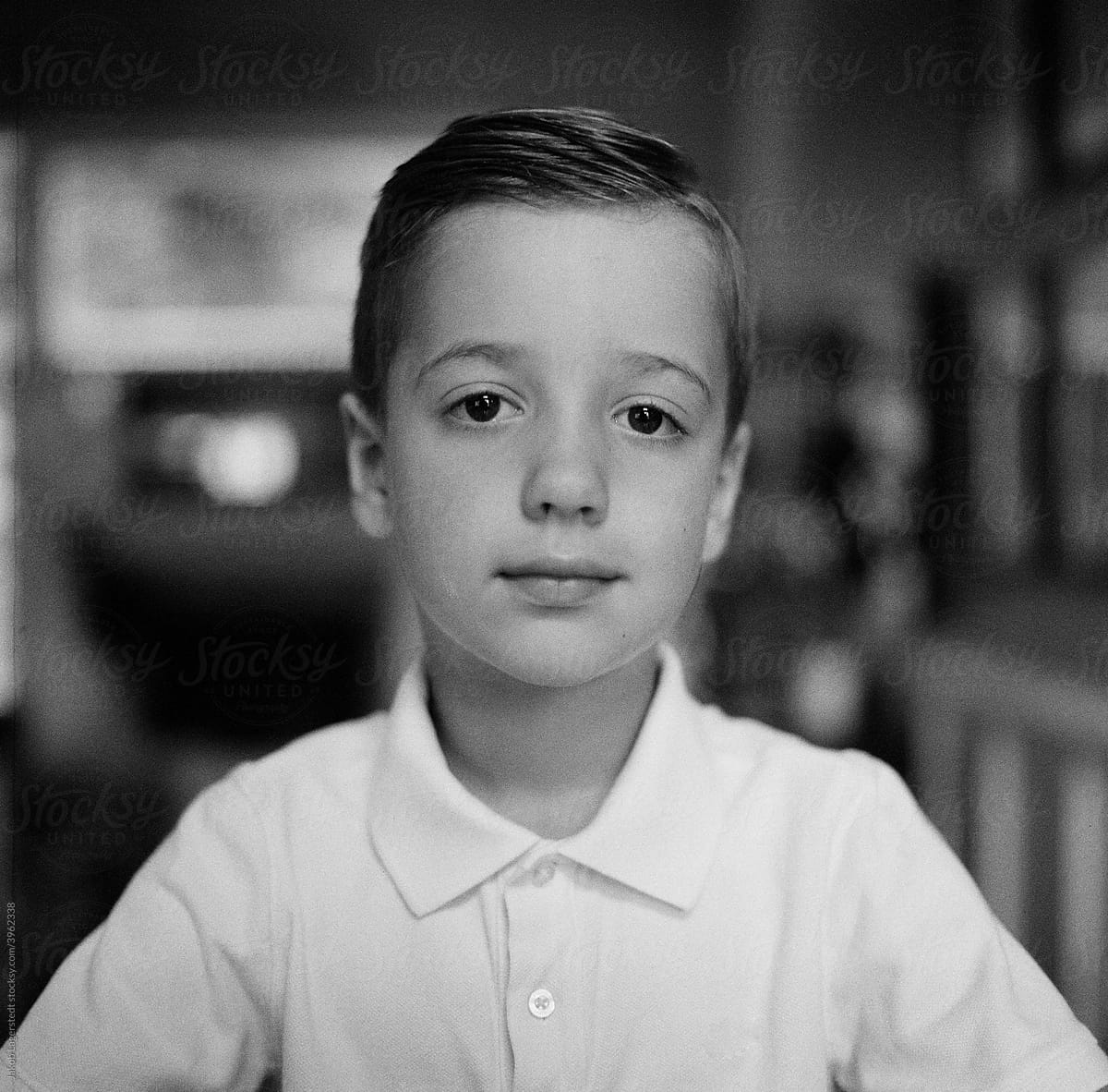 Black and white portrait of a handsome young boy in a white polo shirt
