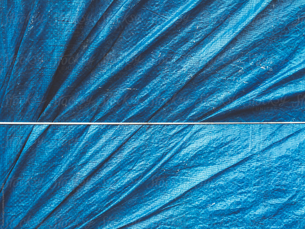 Close up of bound blue tarpaulin covering commercial fishing equipment