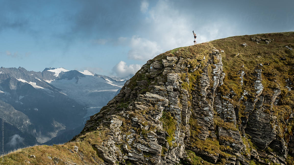 man doing handstand on mountain top