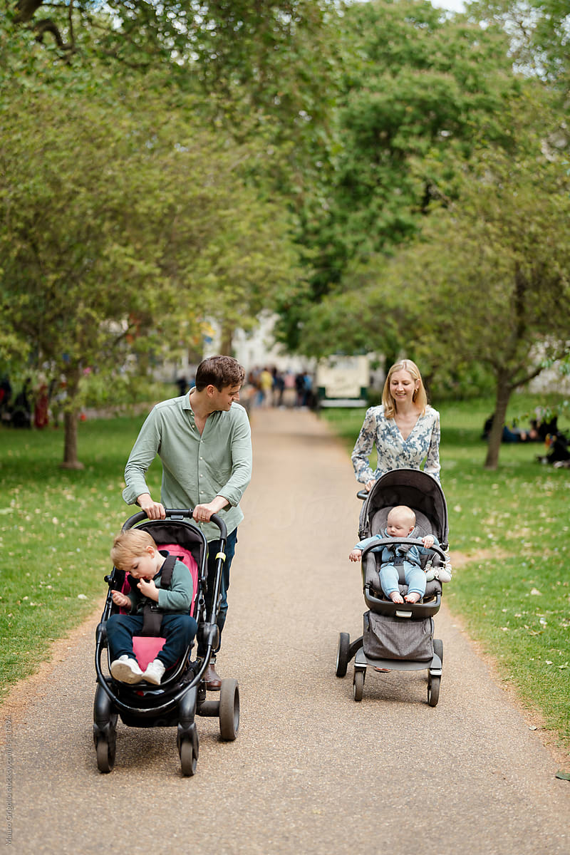 Couple with strollers taking their two children for a walk