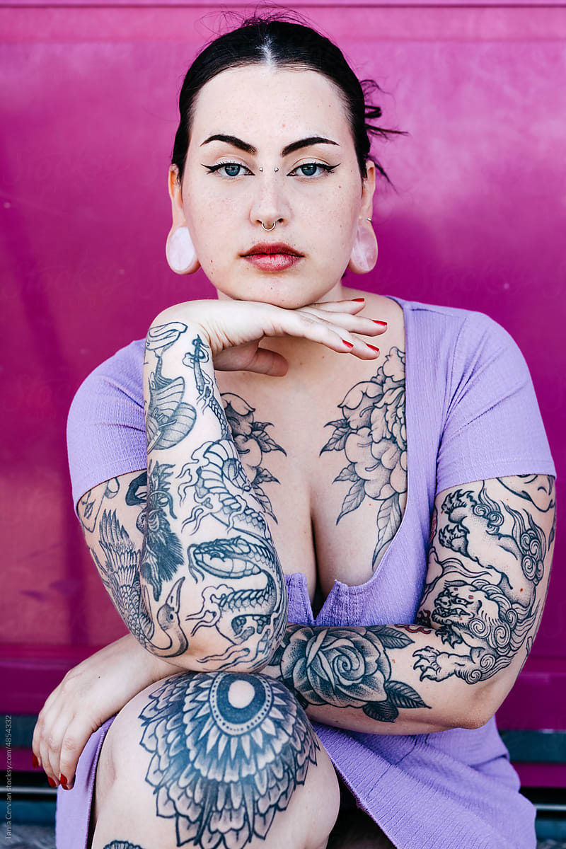 Tattooed curve model with hand under chin