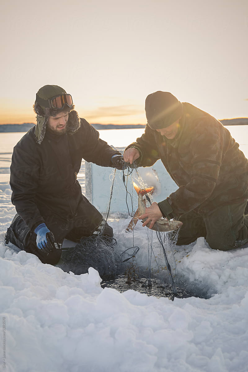 Two men ice fishing together