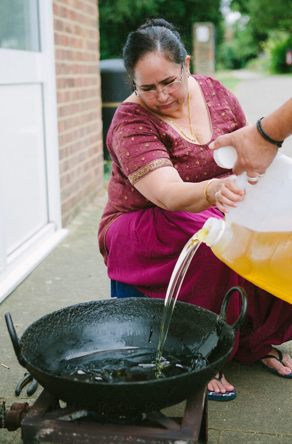 Indian woman cooking using a wok