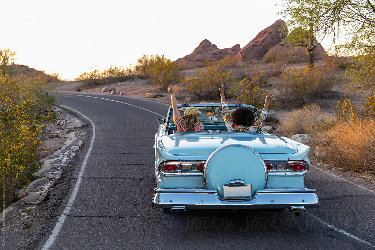 Two Beautiful Girls on Desert Road trip in Convertible car in Arizona