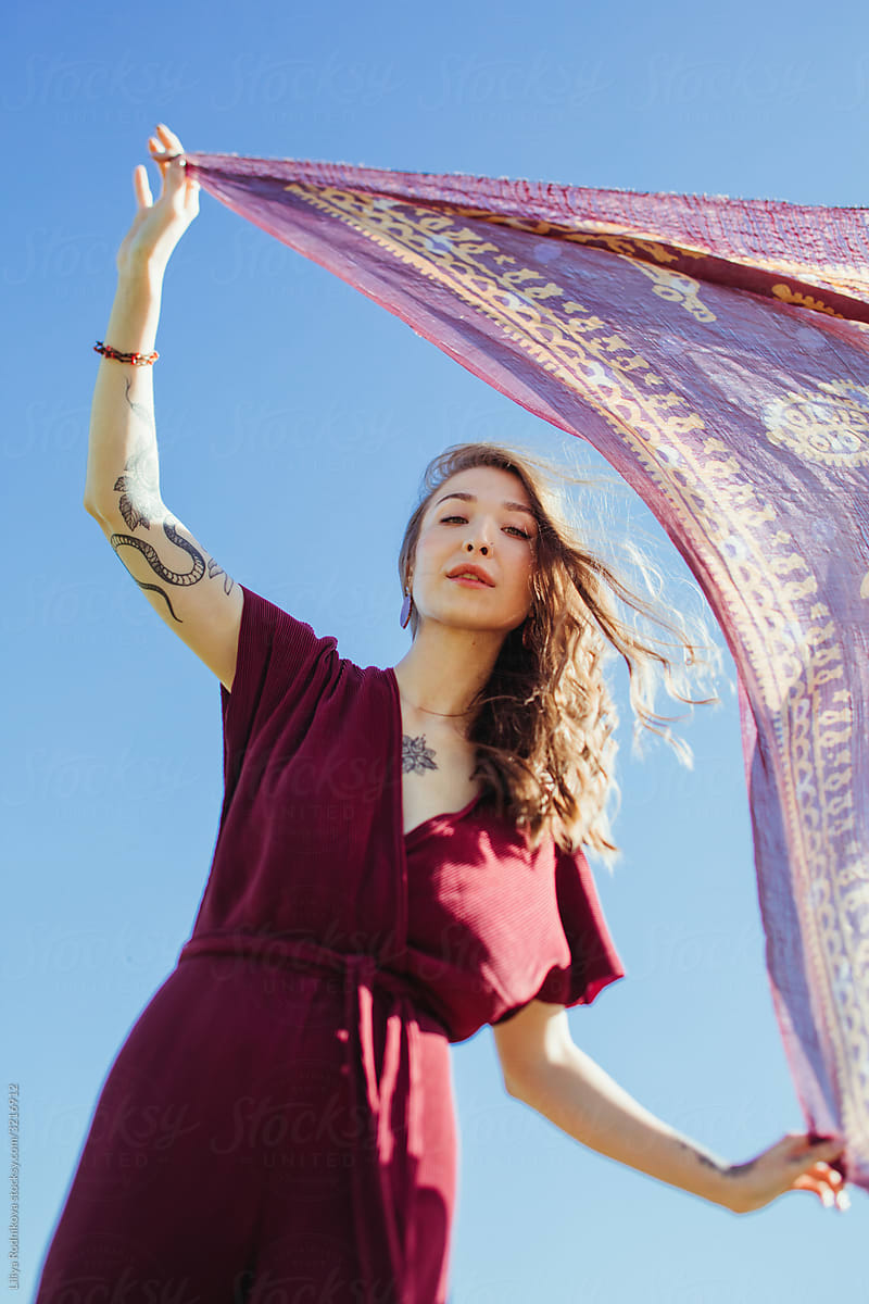 Model posing with scarf against the sky