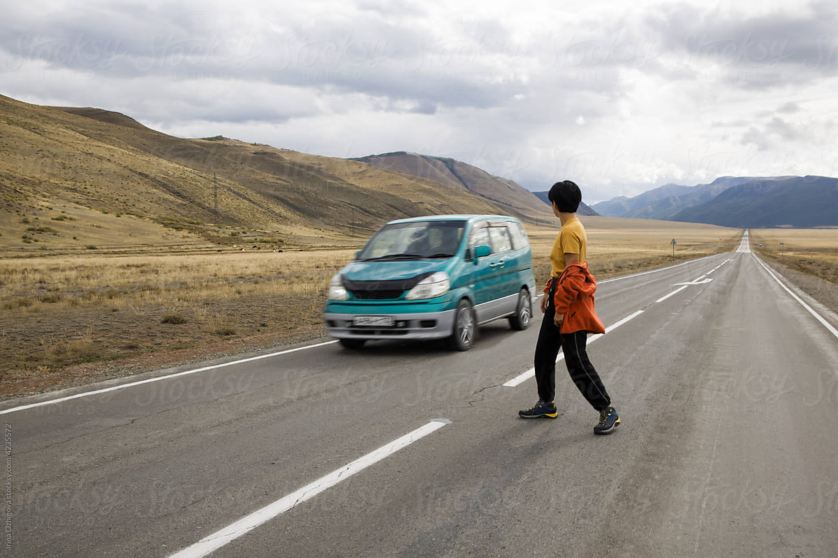 Traveling woman on road near car