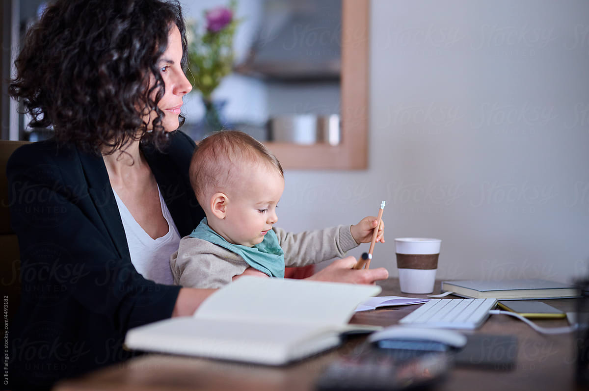 Businesswoman with baby making notes