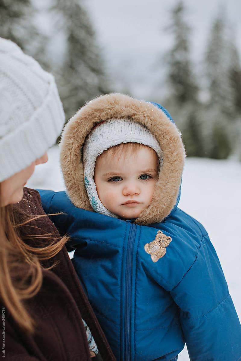Mother Holding Toddler in Outdoor Winter Landscape