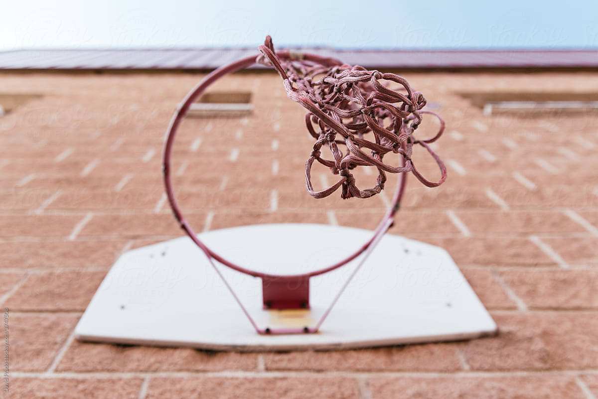 Basketball hoop on brick wall on street